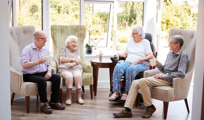 4 elderly woman sit in nice chairs and enjoy a conversation