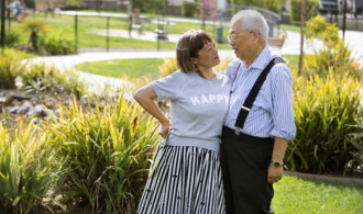 A couple stands in the gardens at Paradise Village