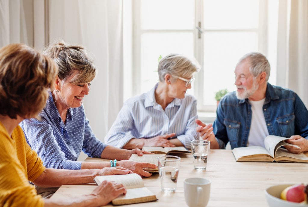 Senior people in reading group in Generations club, talking.